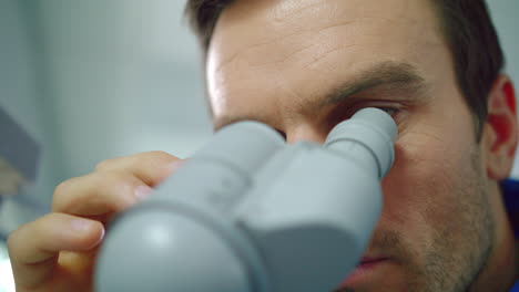 Scientist-face-looking-microscope.-Close-up-of-scientist-looking-microscope